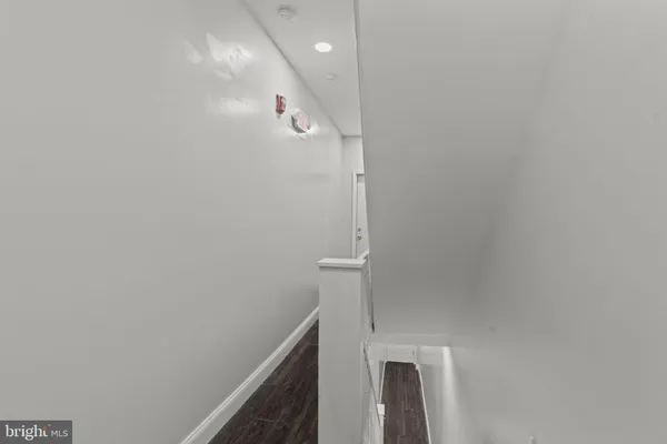 a open kitchen with white cabinets and wooden floor