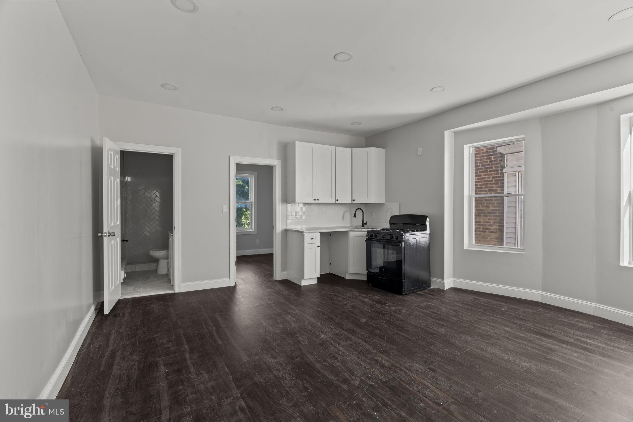 5237 Chester Avenue, Unit 3 Philadelphia, PA 19143 - Photo 18 of 35 a open kitchen with white cabinets and wooden floor