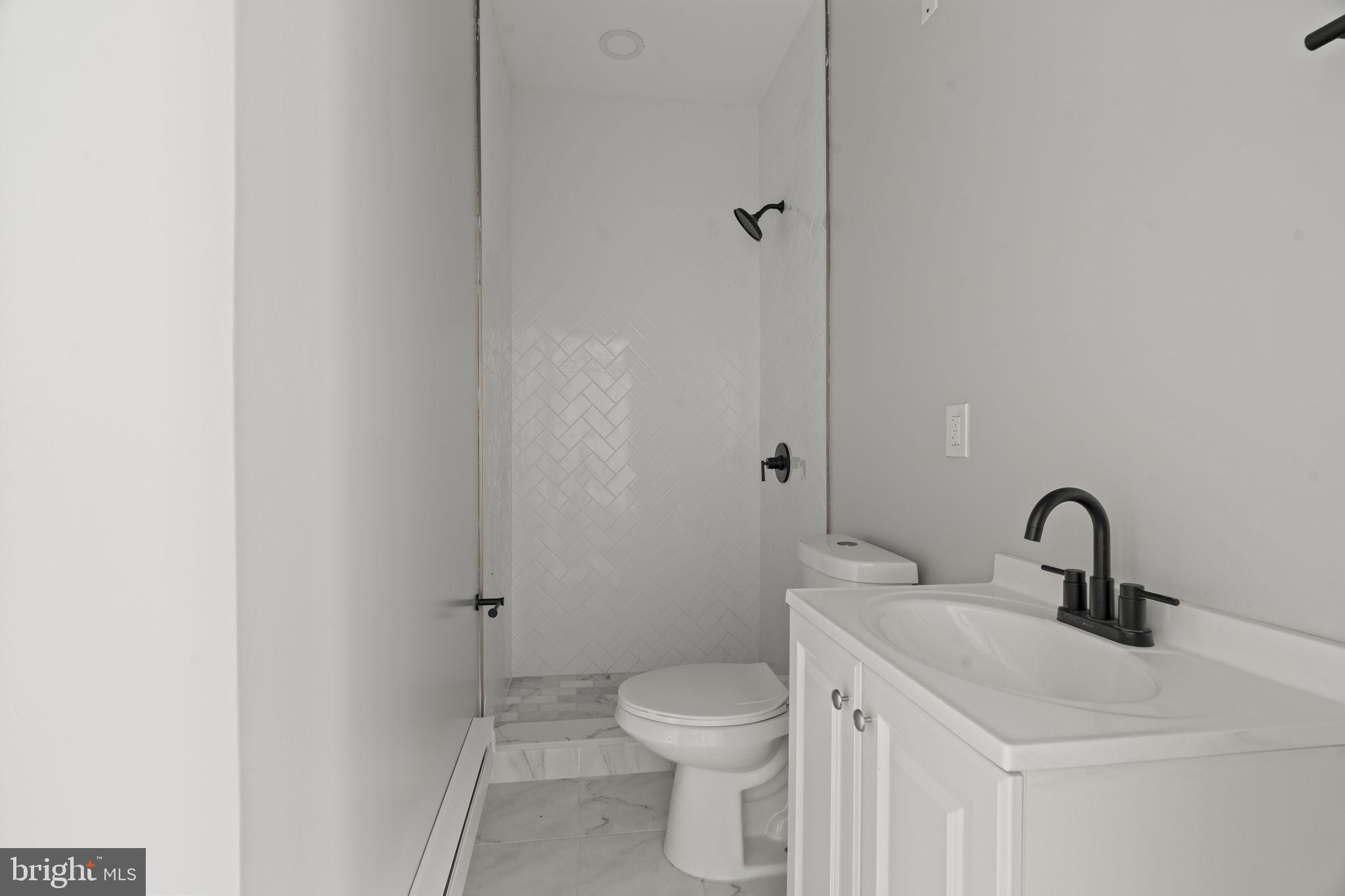 5237 Chester Avenue, Unit 3 Philadelphia, PA 19143 - Photo 22 of 35 a bathroom with a toilet sink vanity and shower