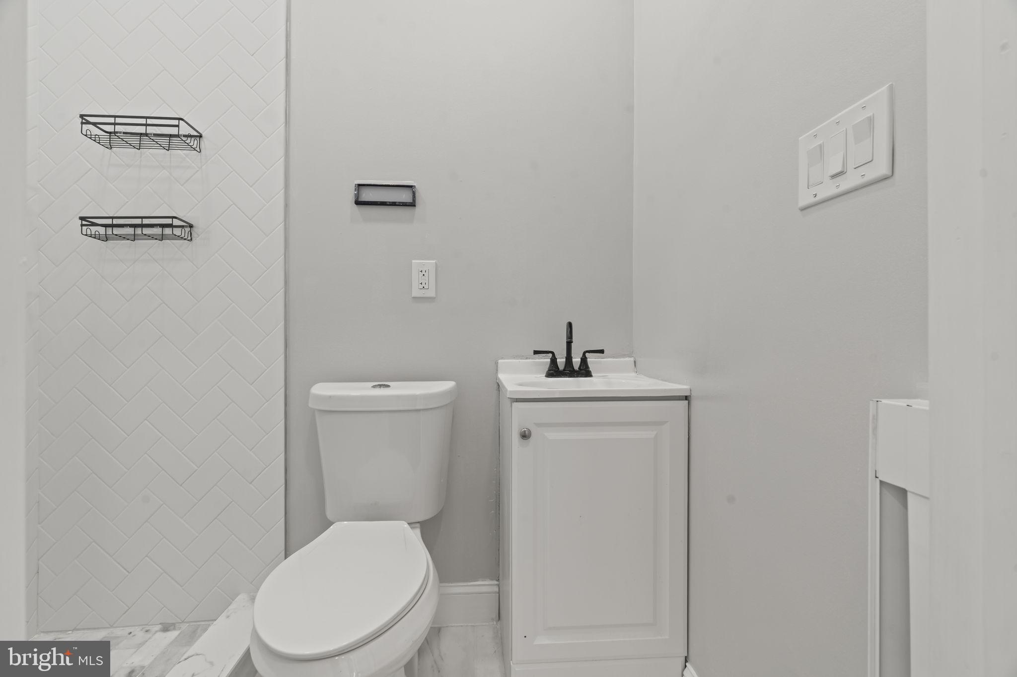 5237 Chester Avenue, Unit 3 Philadelphia, PA 19143 - Photo 26 of 35 a white toilet sitting next to a bathroom sink