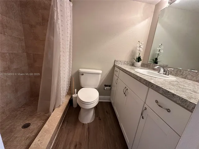 a bathroom with a granite countertop toilet sink and shower