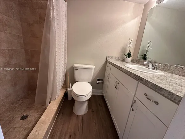 a bathroom with a granite countertop toilet sink and shower