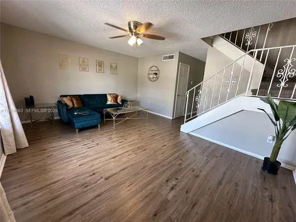 a living room with furniture and a wooden floor