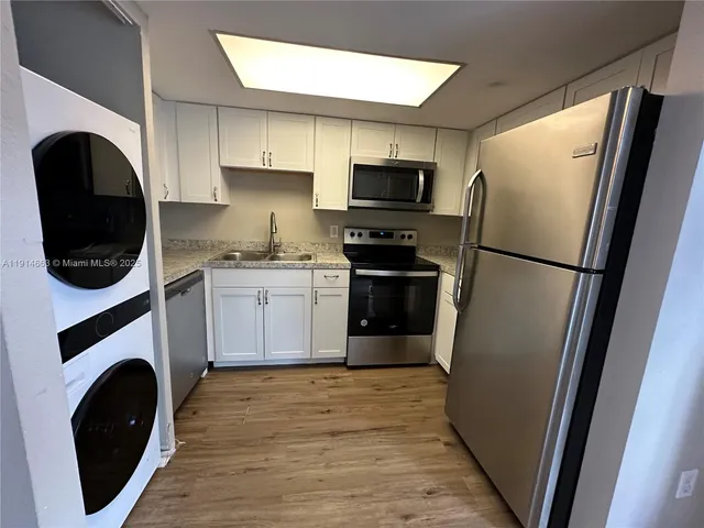 a kitchen with a refrigerator a washer and dryer
