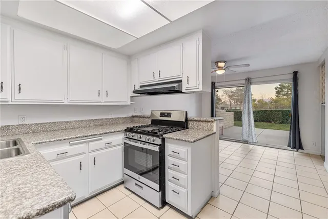 a kitchen with granite countertop white cabinets and white appliances
