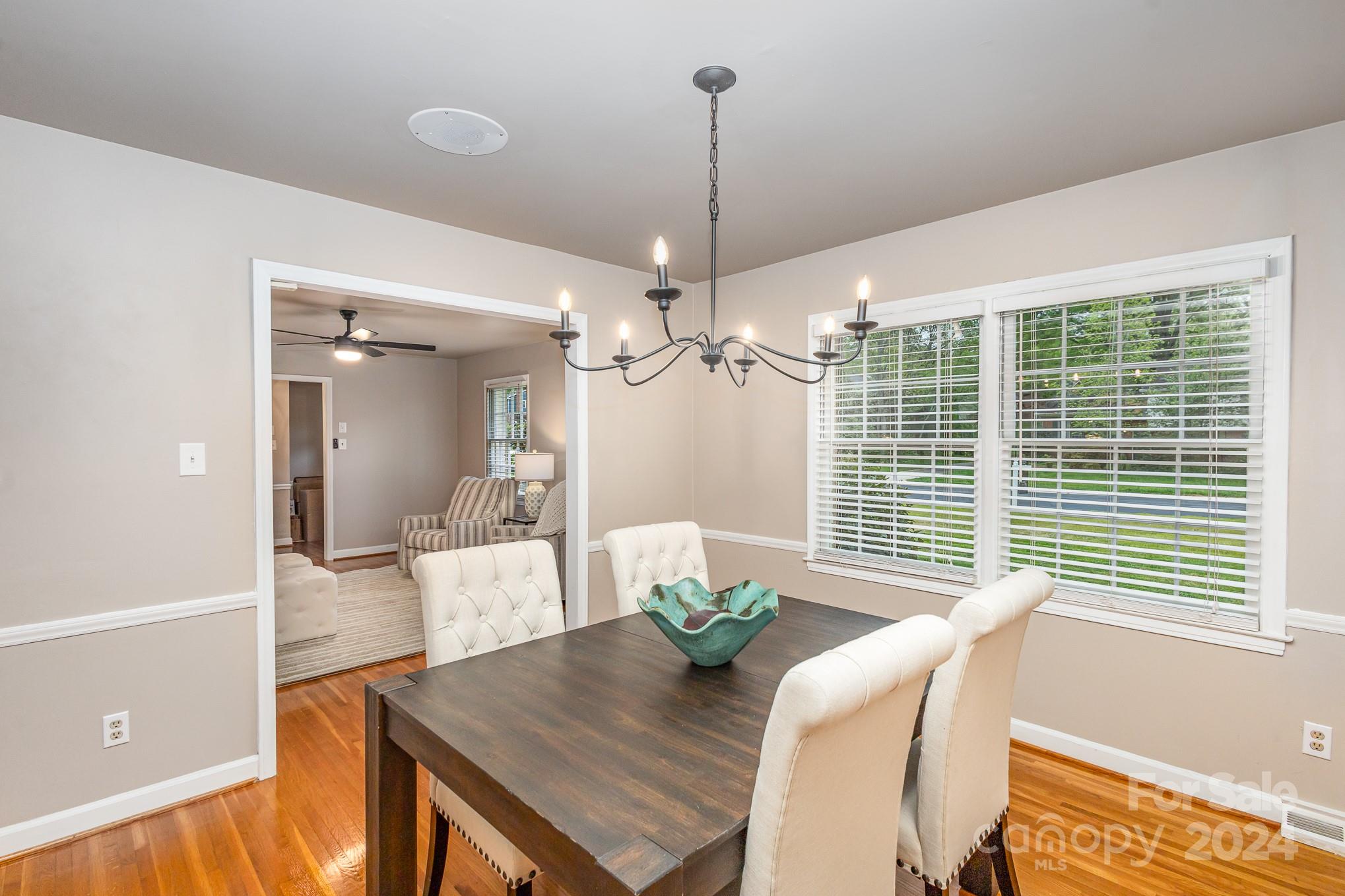 4011 Chandworth Road Charlotte, NC 28210 - Photo 6 of 30 a view of a dining room with furniture a chandelier and wooden floor