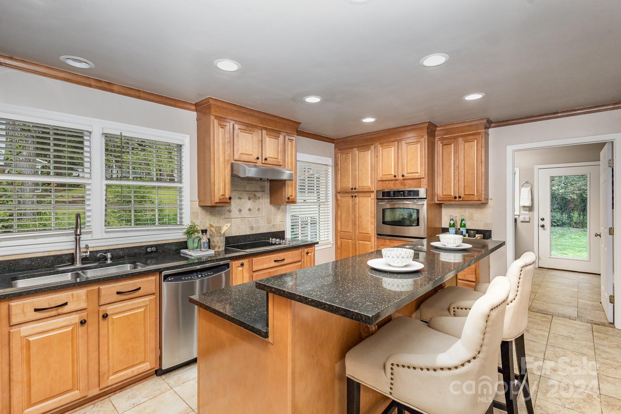 4011 Chandworth Road Charlotte, NC 28210 - Photo 9 of 30 a kitchen with granite countertop kitchen island stainless steel appliances a sink and cabinets