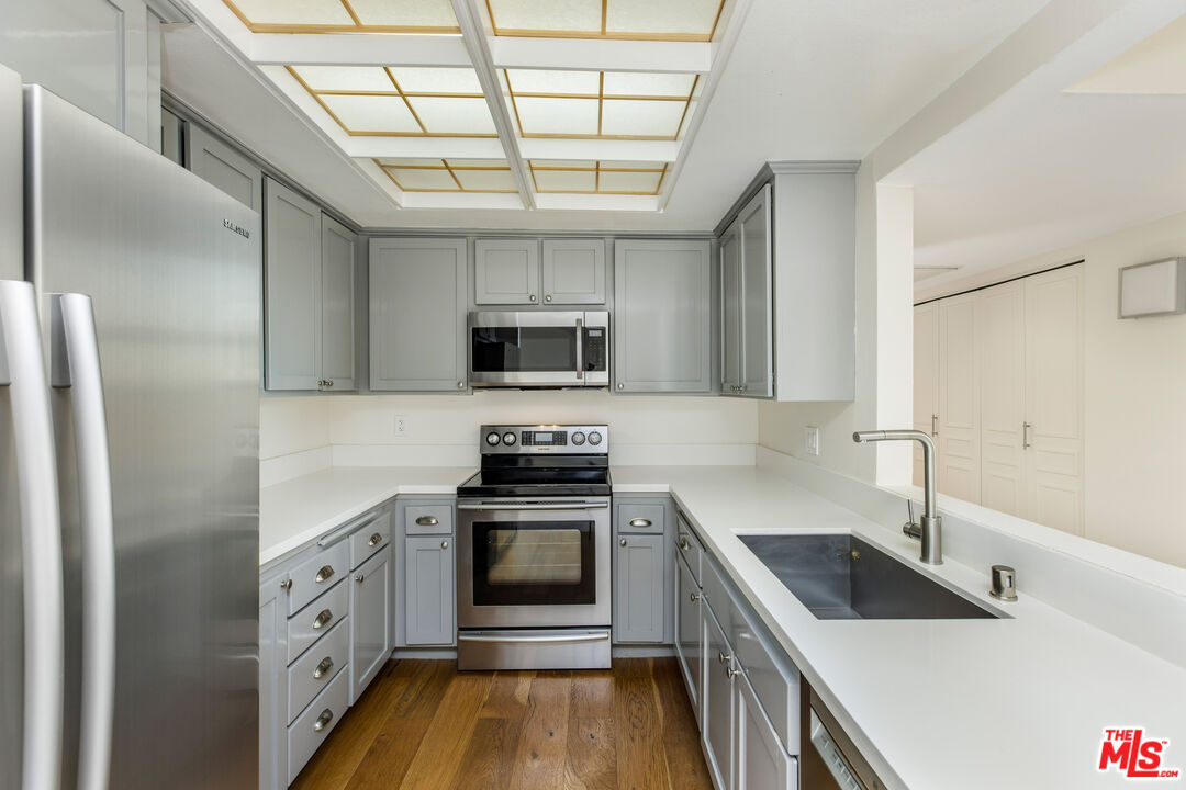 2385 Roscomare Road, Unit F4 Los Angeles, CA 90077 - Photo 18 of 57 a kitchen with stainless steel appliances granite countertop a sink and a stove