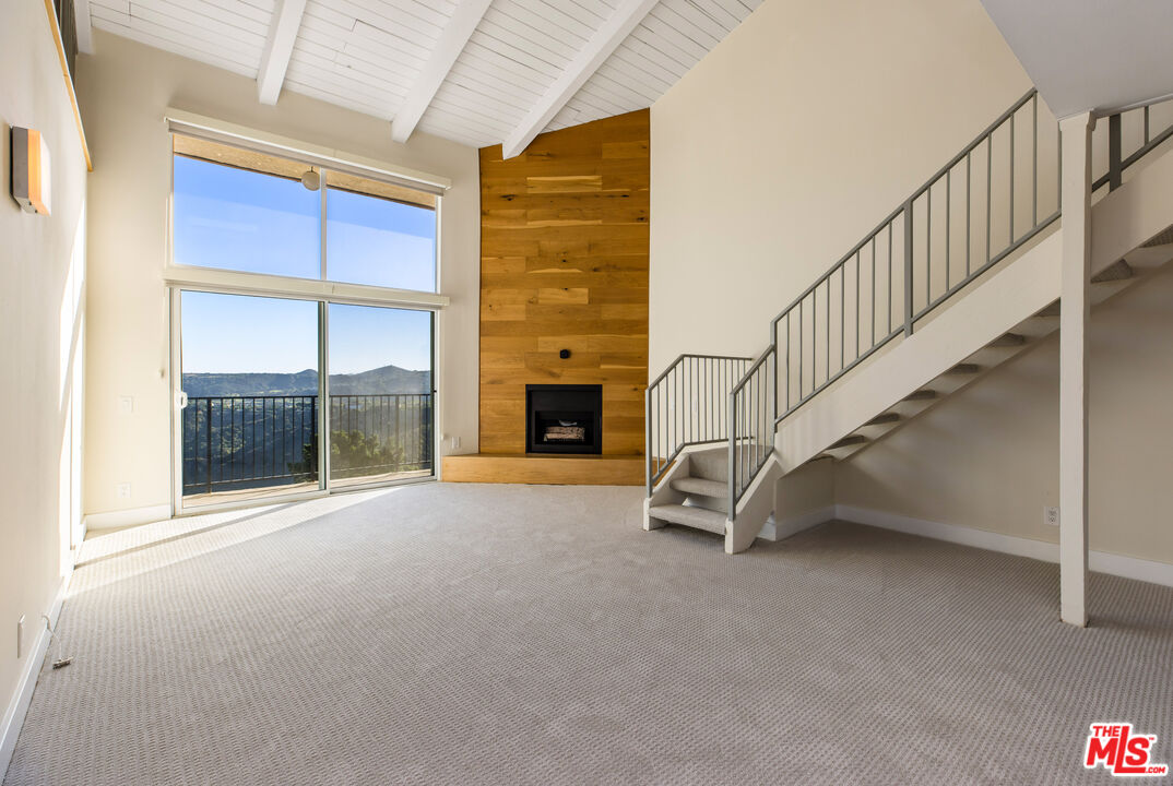 2385 Roscomare Road, Unit F4 Los Angeles, CA 90077 - Photo 2 of 57 a view of an empty room with wooden floor and a window