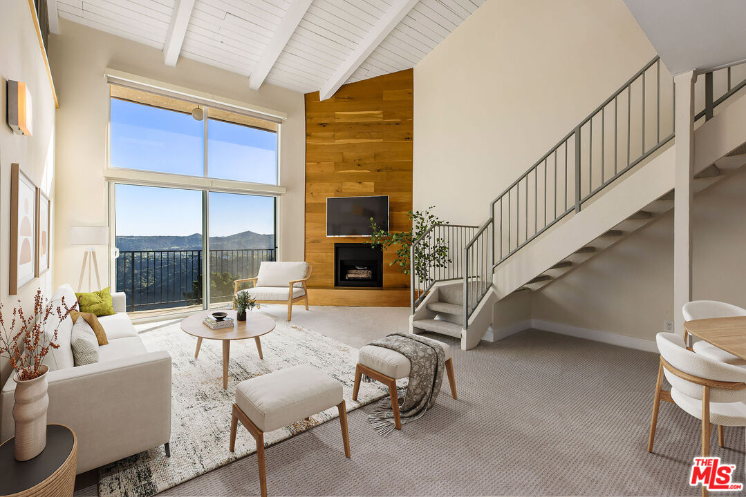 2385 Roscomare Road, Unit F4 Los Angeles, CA 90077 - Photo 3 of 57 a living room with furniture a fireplace and a large window