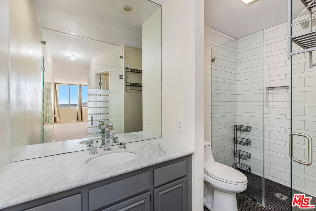 2385 Roscomare Road, Unit F4 Los Angeles, CA 90077 - Photo 10 of 57 a bathroom with a granite countertop sink mirror and toilet
