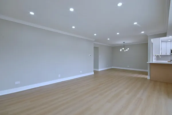 a view of empty room with wooden floor