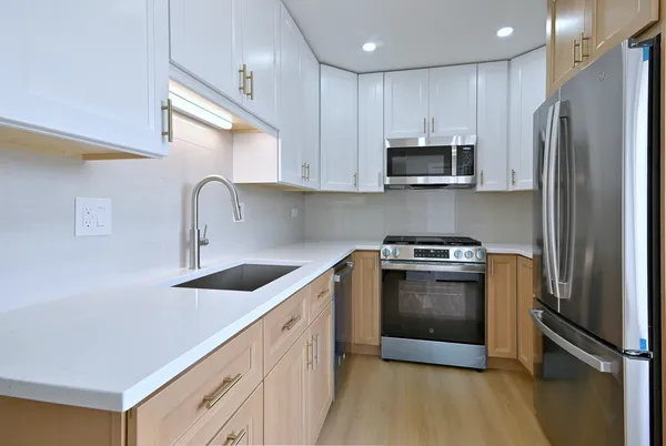 a kitchen with stainless steel appliances granite countertop a refrigerator and a sink