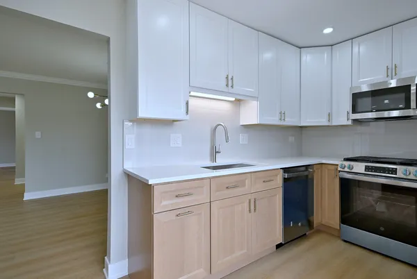 a kitchen with cabinets appliances and a sink