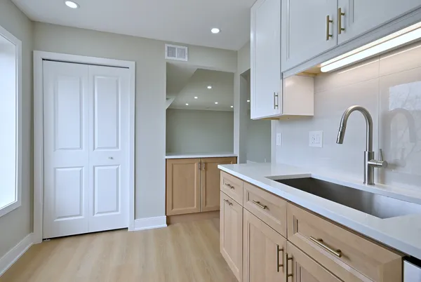 a kitchen with stainless steel appliances granite countertop a sink and a white cabinets