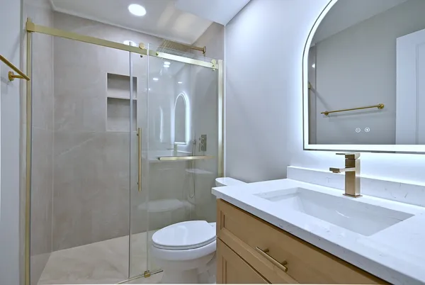 a bathroom with a sink a toilet and shower
