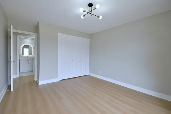 wooden floor in an empty room with a bathroom