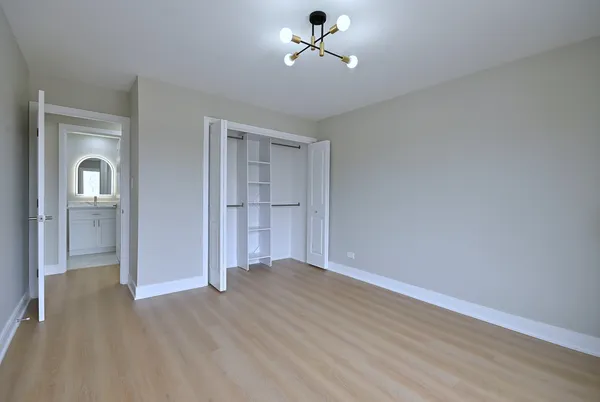 a view of empty room with wooden floor and ceiling fan