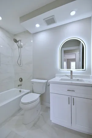 a bathroom with a toilet sink and mirror