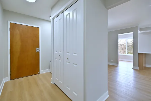 a view of a room with wooden floor and a bathroom