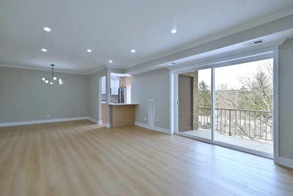a view of a big room with wooden floor and windows