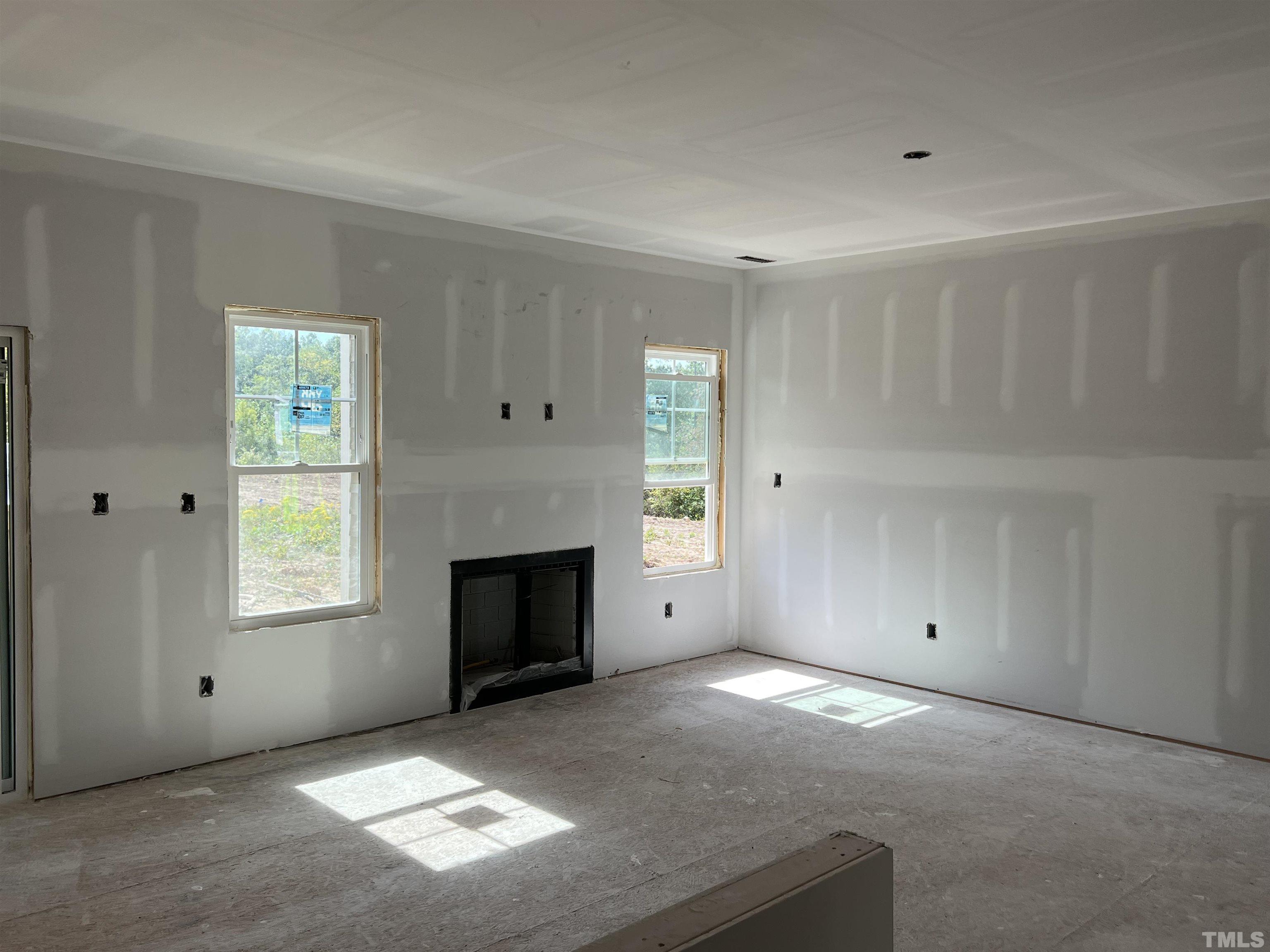 4450 Debnam Road Zebulon, NC 27597 - Photo 5 of 6 an empty room with windows and fireplace