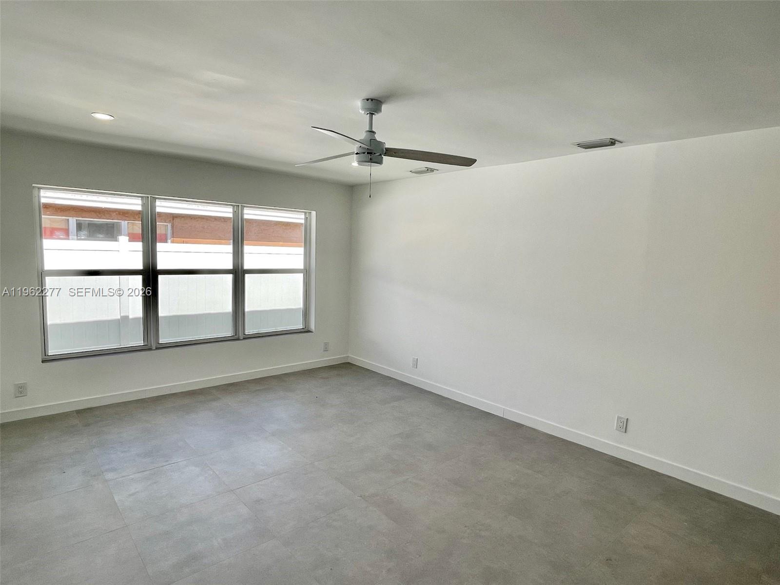 5701 Northwest 28th Street, Unit 13 Lauderhill, FL 33313 - Photo 25 of 34 an empty room with windows and ceiling fan