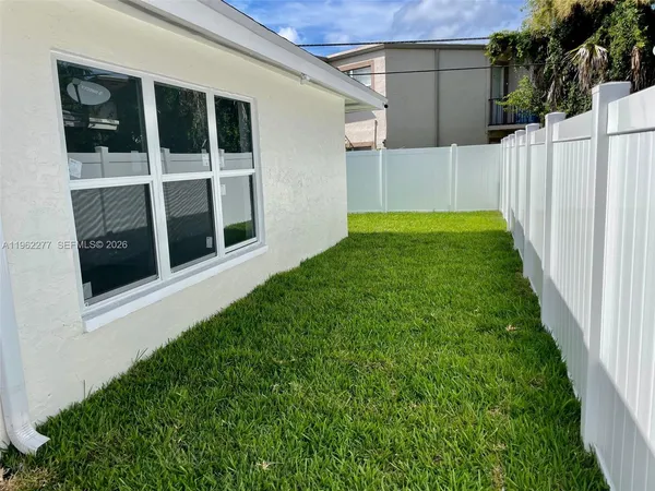a backyard of a house with table and chairs