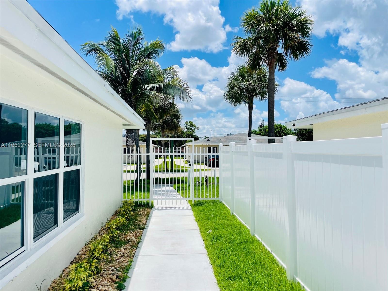 5701 Northwest 28th Street, Unit 13 Lauderhill, FL 33313 - Photo 34 of 34 a view of a house with a small yard and large trees