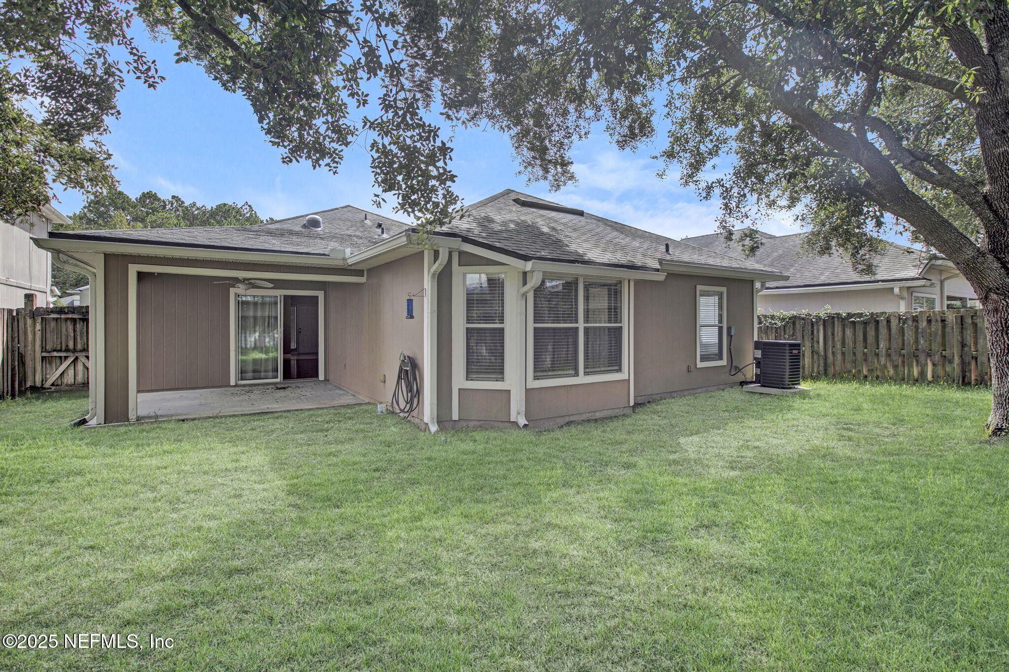 a view of a house with a yard and a large tree