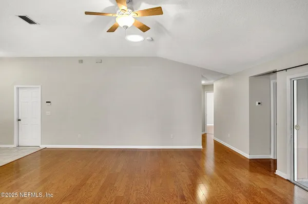 a view of an empty room with wooden floor