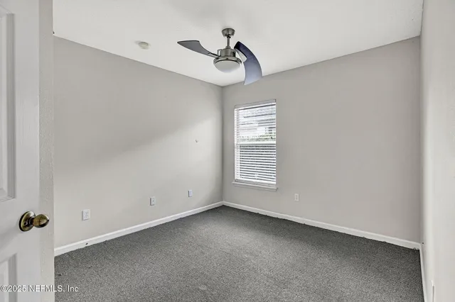 a view of a room with a window and a ceiling fan