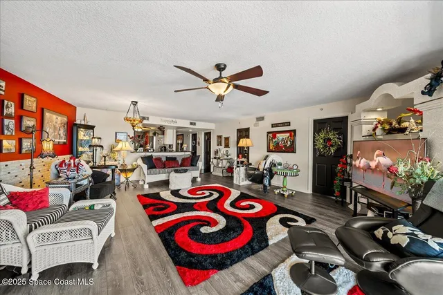 a living room with furniture a flat screen tv and a floor to ceiling window