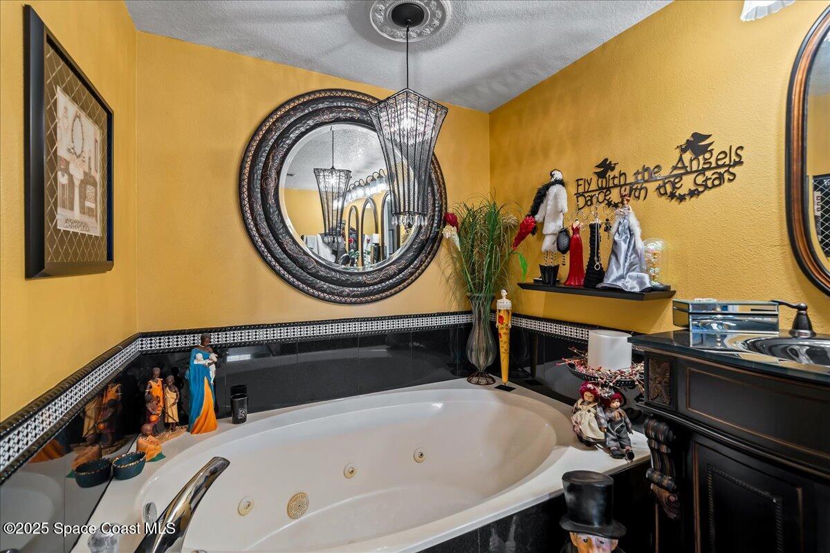 104 Riverside Drive, Unit 203 Cocoa, FL 32922 - Photo 26 of 48 a bedroom with a bed and a chandelier