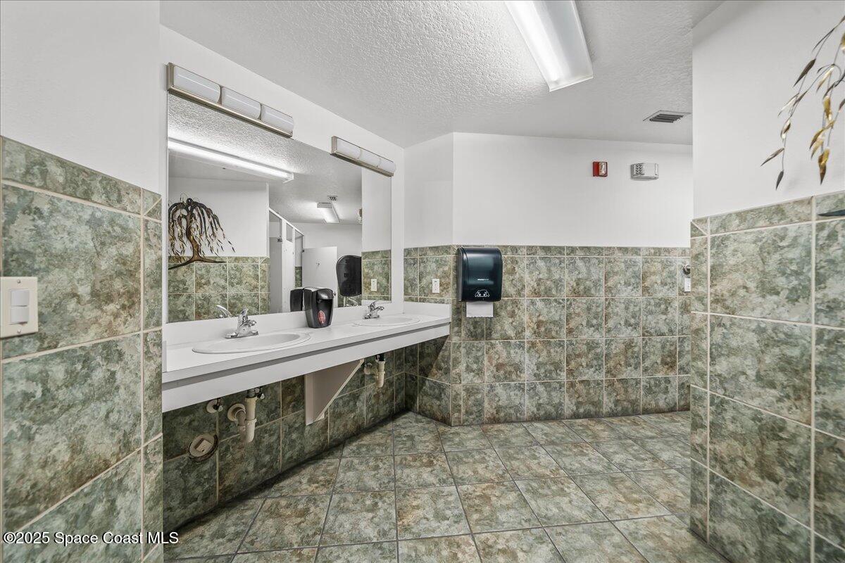 104 Riverside Drive, Unit 203 Cocoa, FL 32922 - Photo 40 of 48 a bathroom with a sink mirror and a shower