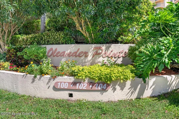 a wooden sign with tree in the background