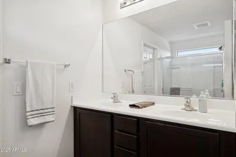a bathroom with double sink and a mirror
