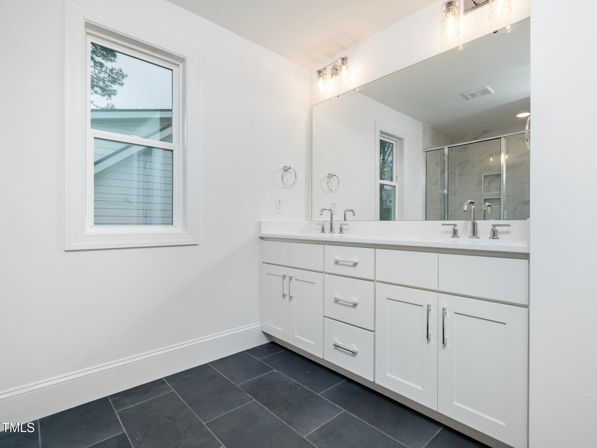 1223 Chaney Road Raleigh, NC 27606 - Photo 20 of 25 a bathroom with a sink vanity and mirror