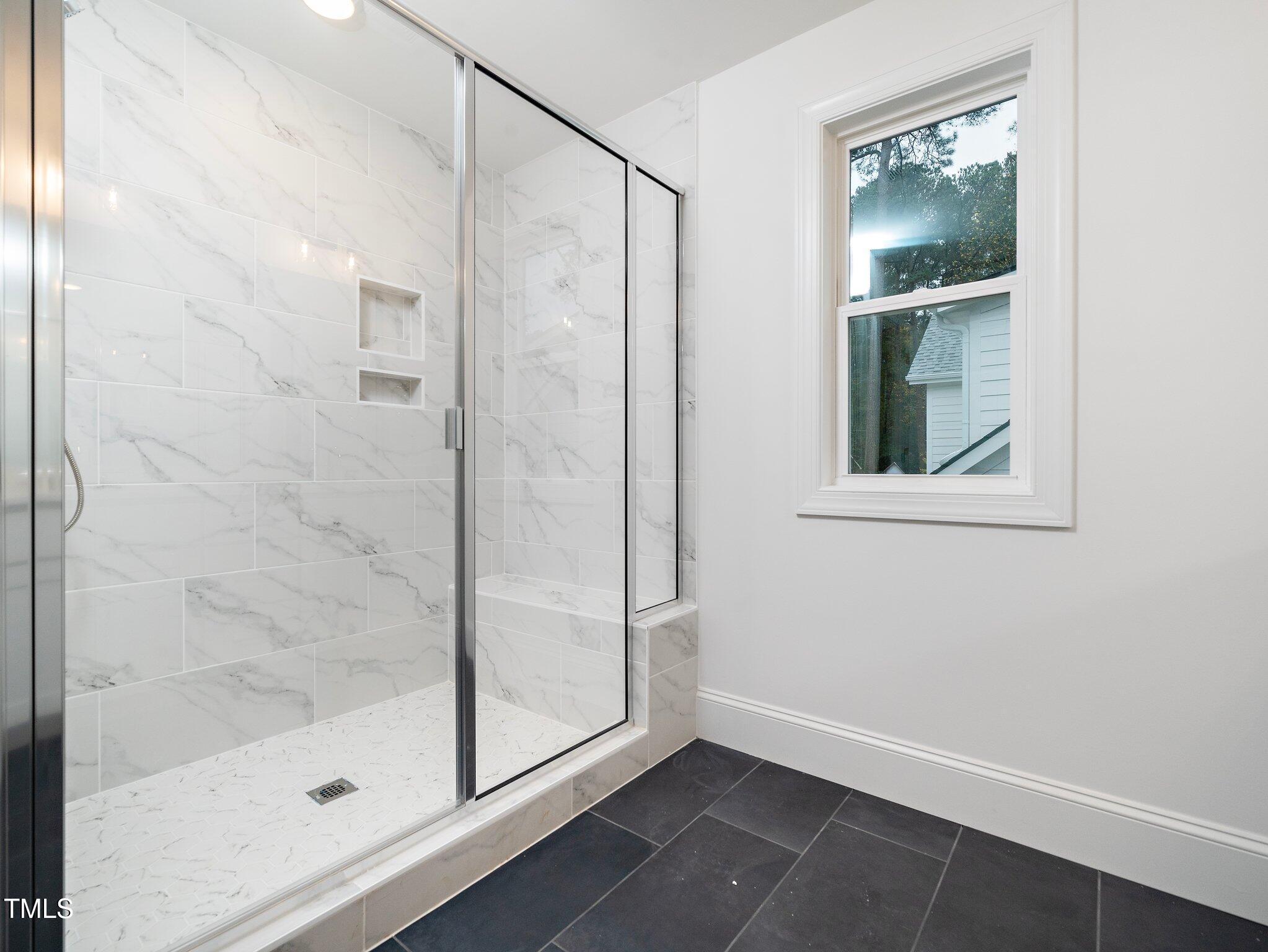 1223 Chaney Road Raleigh, NC 27606 - Photo 21 of 25 a bathroom with a glass shower door and a window
