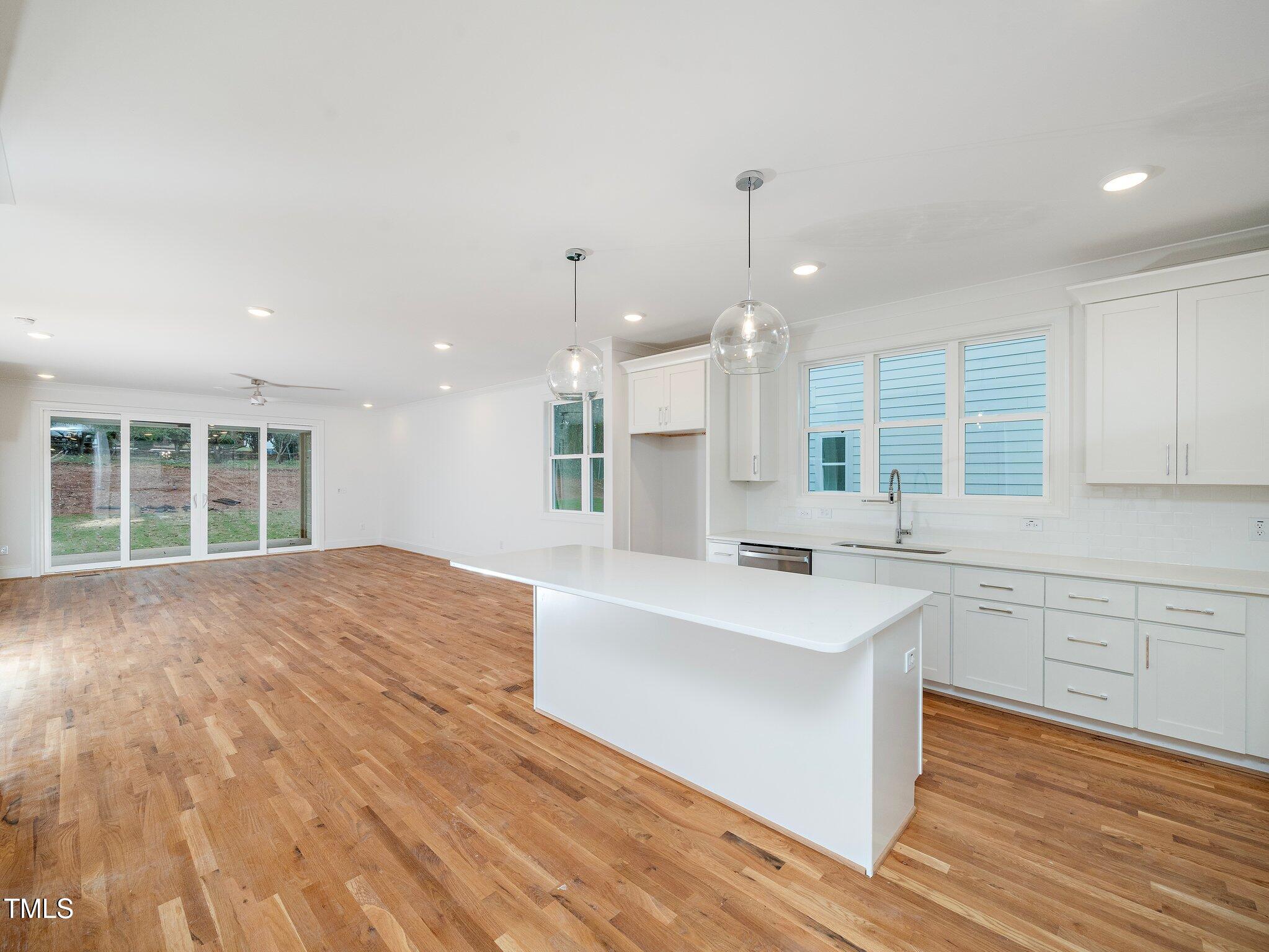 1223 Chaney Road Raleigh, NC 27606 - Photo 4 of 25 a large kitchen with kitchen island a sink stainless steel appliances and cabinets