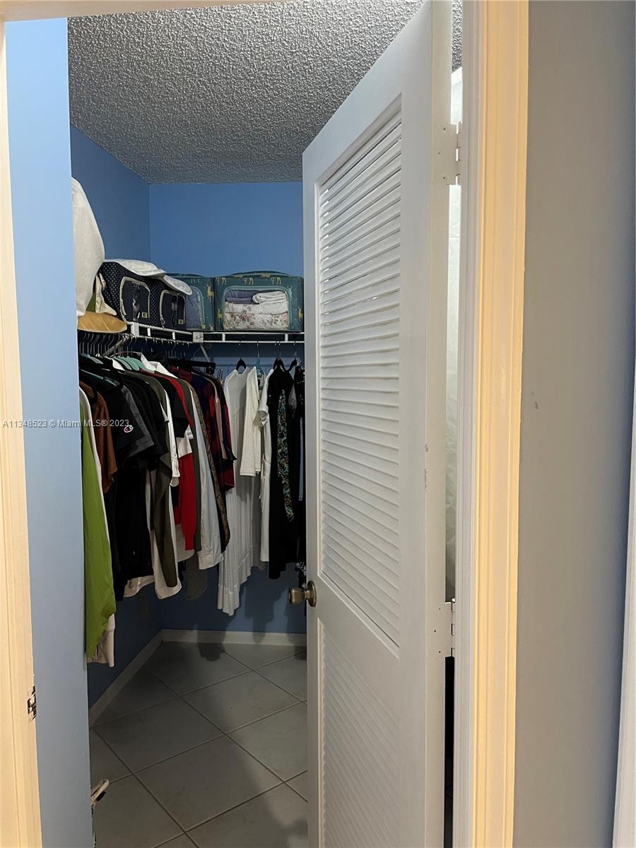 23370 Carolwood Lane, Unit 2202 Boca Raton, FL 33428 - Photo 15 of 31 a view of walk in closet with clothes