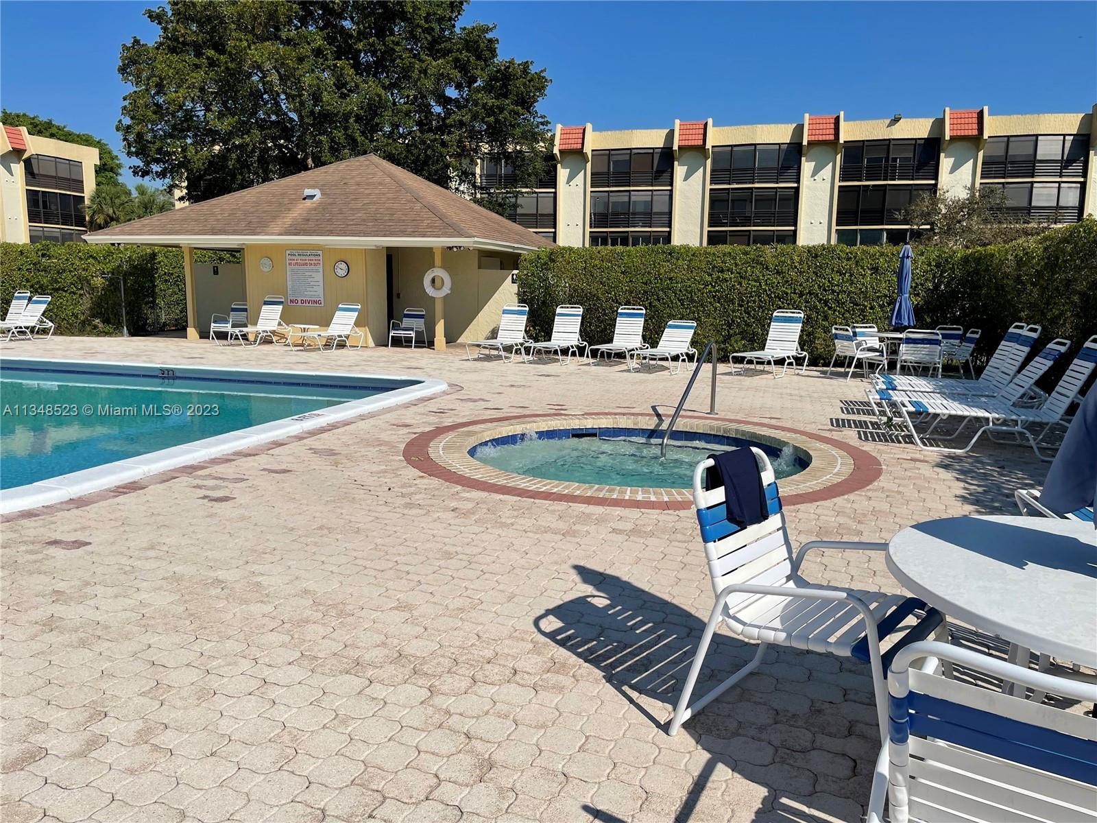 23370 Carolwood Lane, Unit 2202 Boca Raton, FL 33428 - Photo 23 of 31 a front view of a house with swimming pool and porch