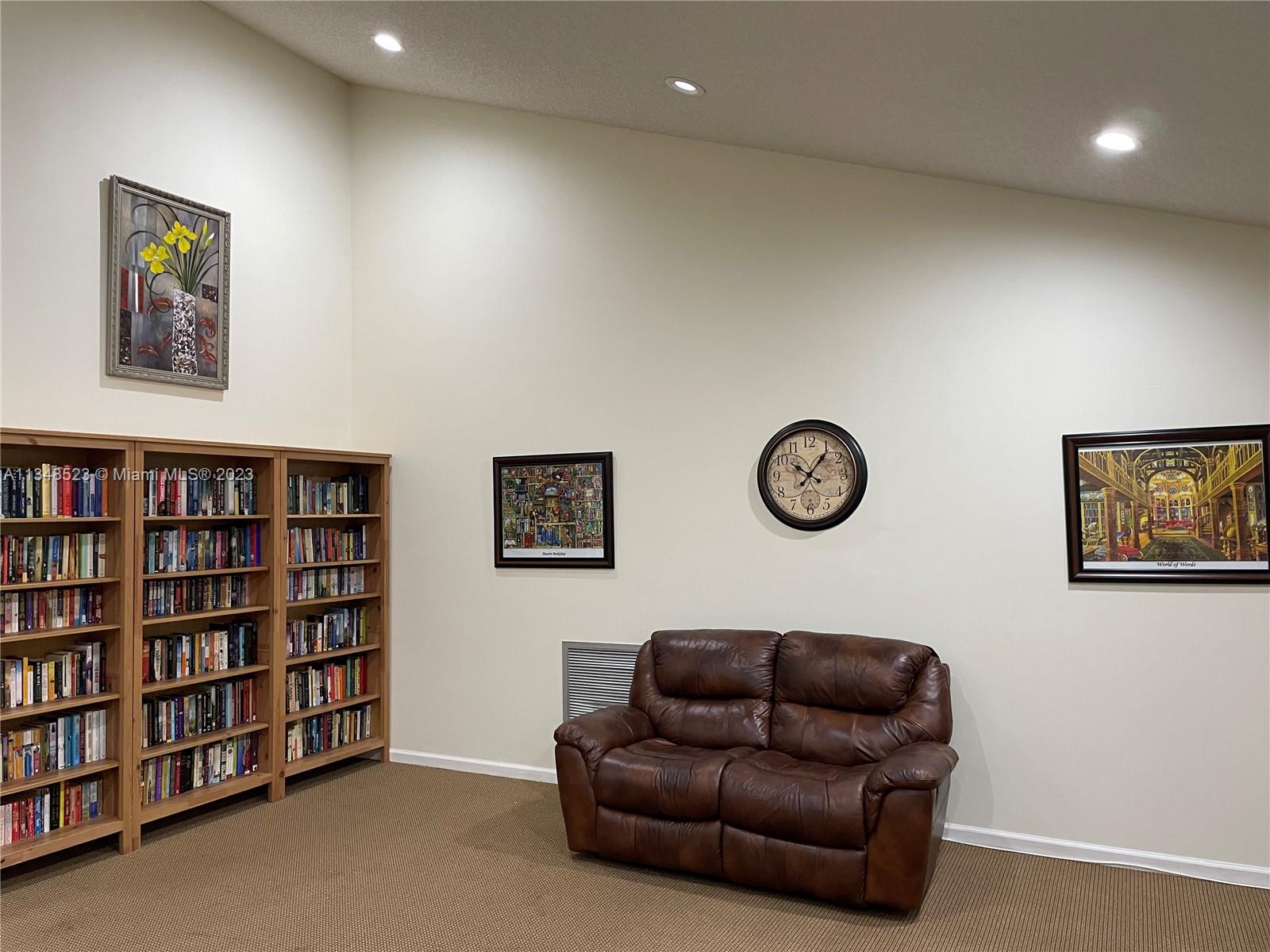 23370 Carolwood Lane, Unit 2202 Boca Raton, FL 33428 - Photo 26 of 31 a living room with furniture and book shelf