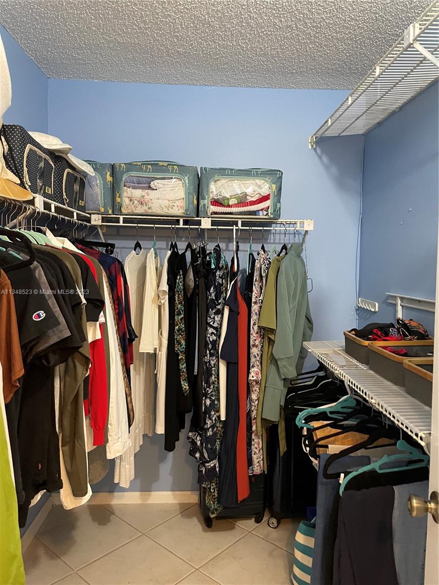 23370 Carolwood Lane, Unit 2202 Boca Raton, FL 33428 - Photo 9 of 31 a view of walk in closet with clothes