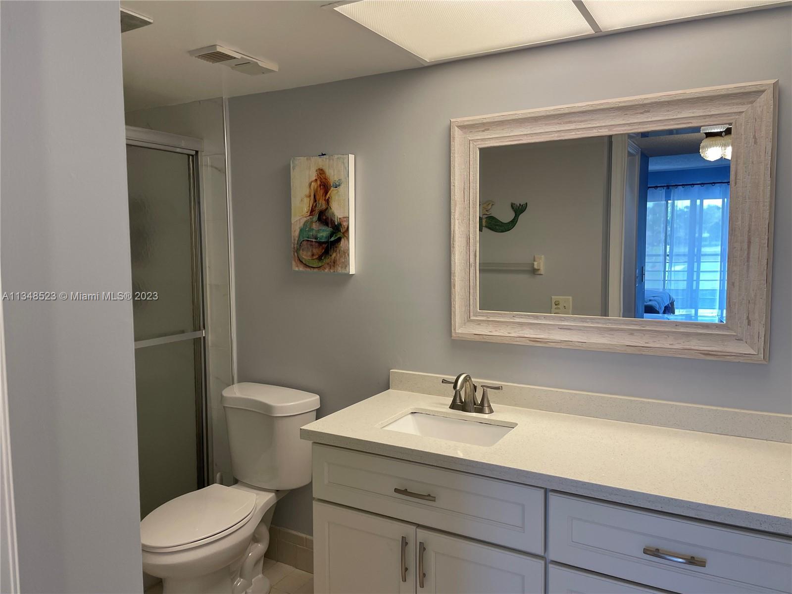 23370 Carolwood Lane, Unit 2202 Boca Raton, FL 33428 - Photo 10 of 31 a bathroom with a sink a toilet and mirror