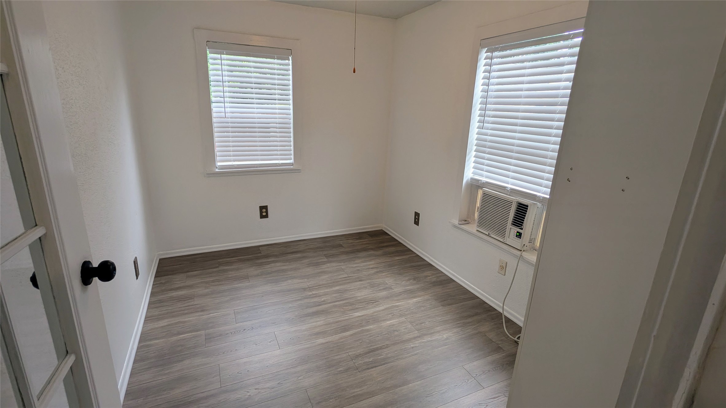 4615 Woodside Street Houston, TX 77023 - Photo 22 of 25 an empty room with wooden floor and a window