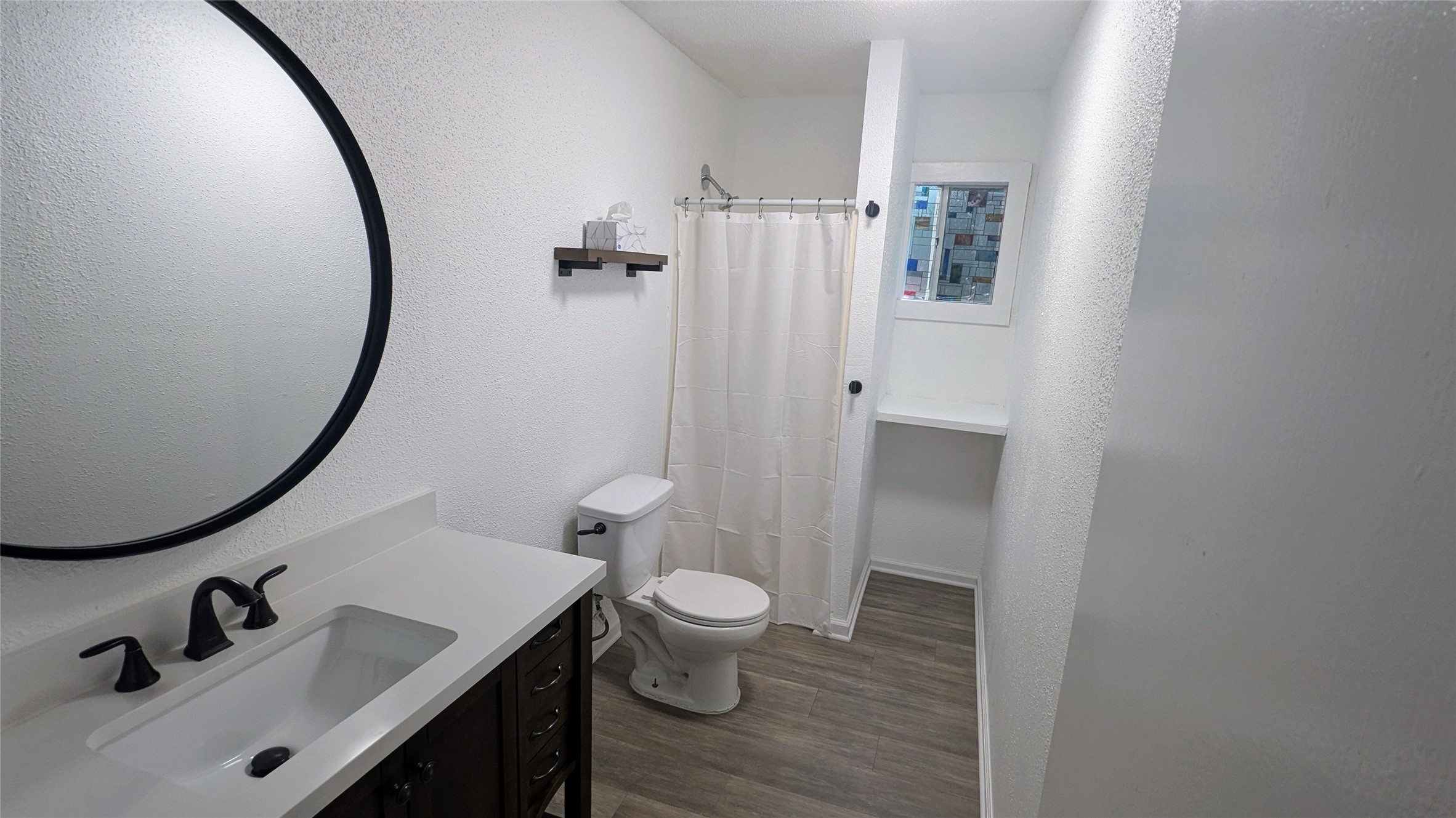 4615 Woodside Street Houston, TX 77023 - Photo 23 of 25 a bathroom with a sink a toilet and a mirror