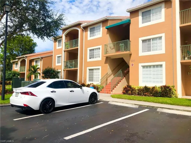 a view of a cars park in front of a brick house