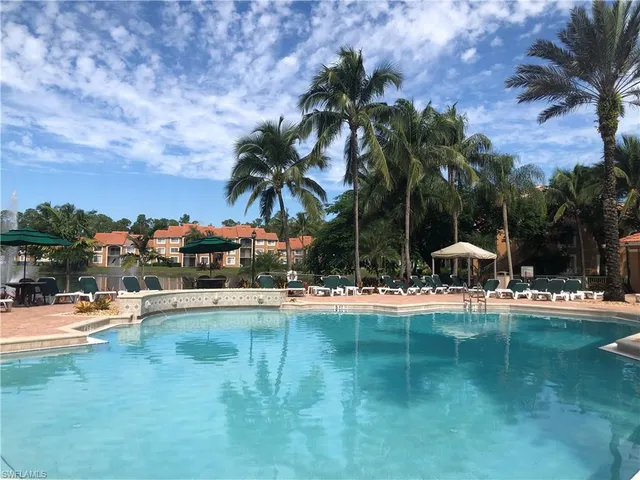 a view of swimming pool with table and chairs and a barbeque