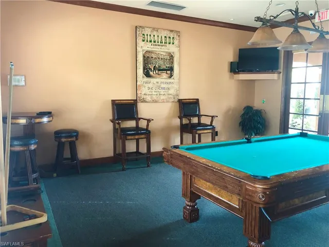 a room with pool table and windows